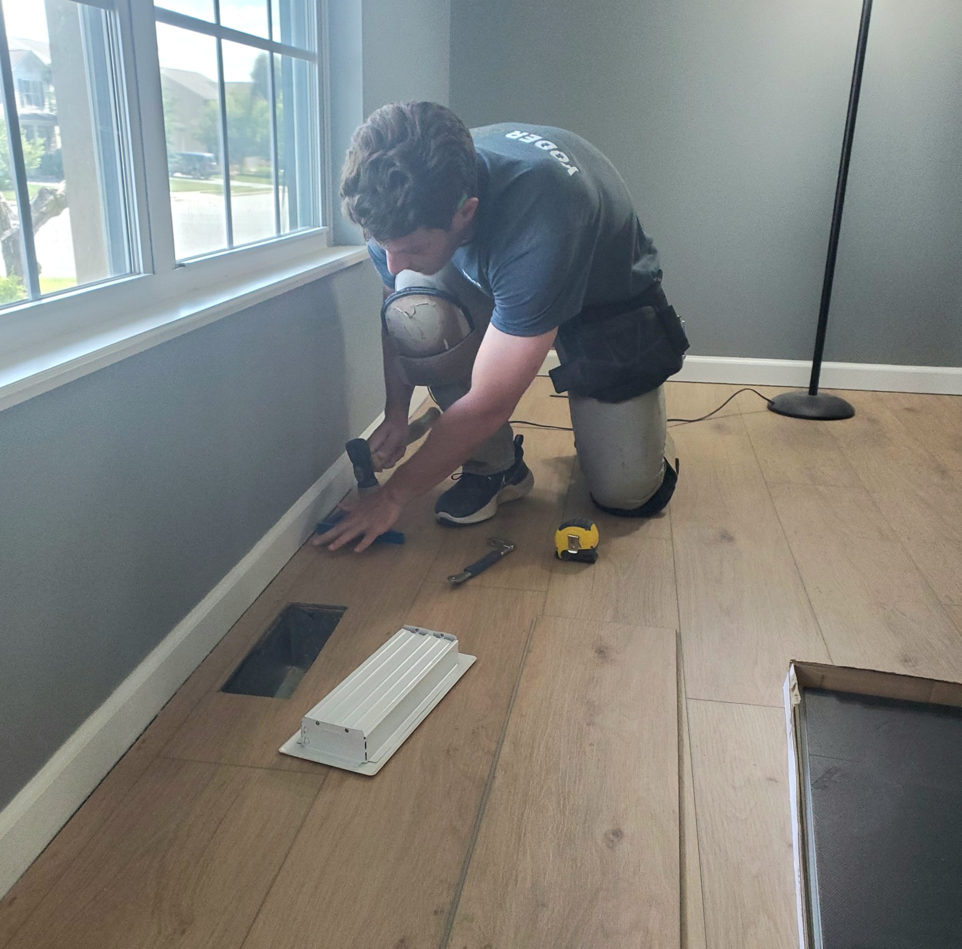 Yoder Flooring installer working on a hardwood installation in a home