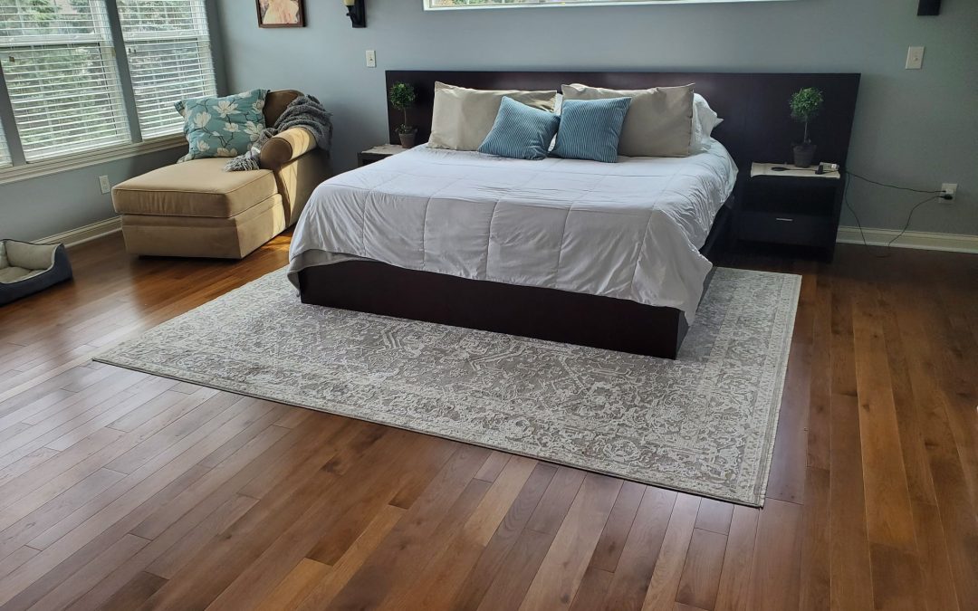 Well-lit master bedroom with solid hickory hardwood floors from Yoder Floors.